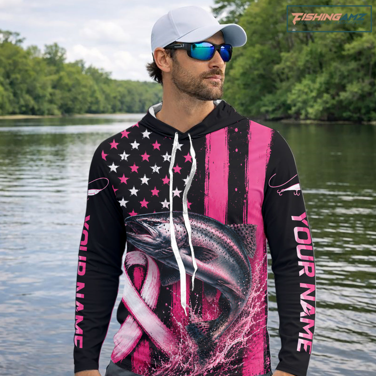 A man wearing a custom black and pink fishing hoodie with a fish graphic and 'YOUR NAME' printed on the sleeve, standing on a boat with fishing rods and the ocean in the background.