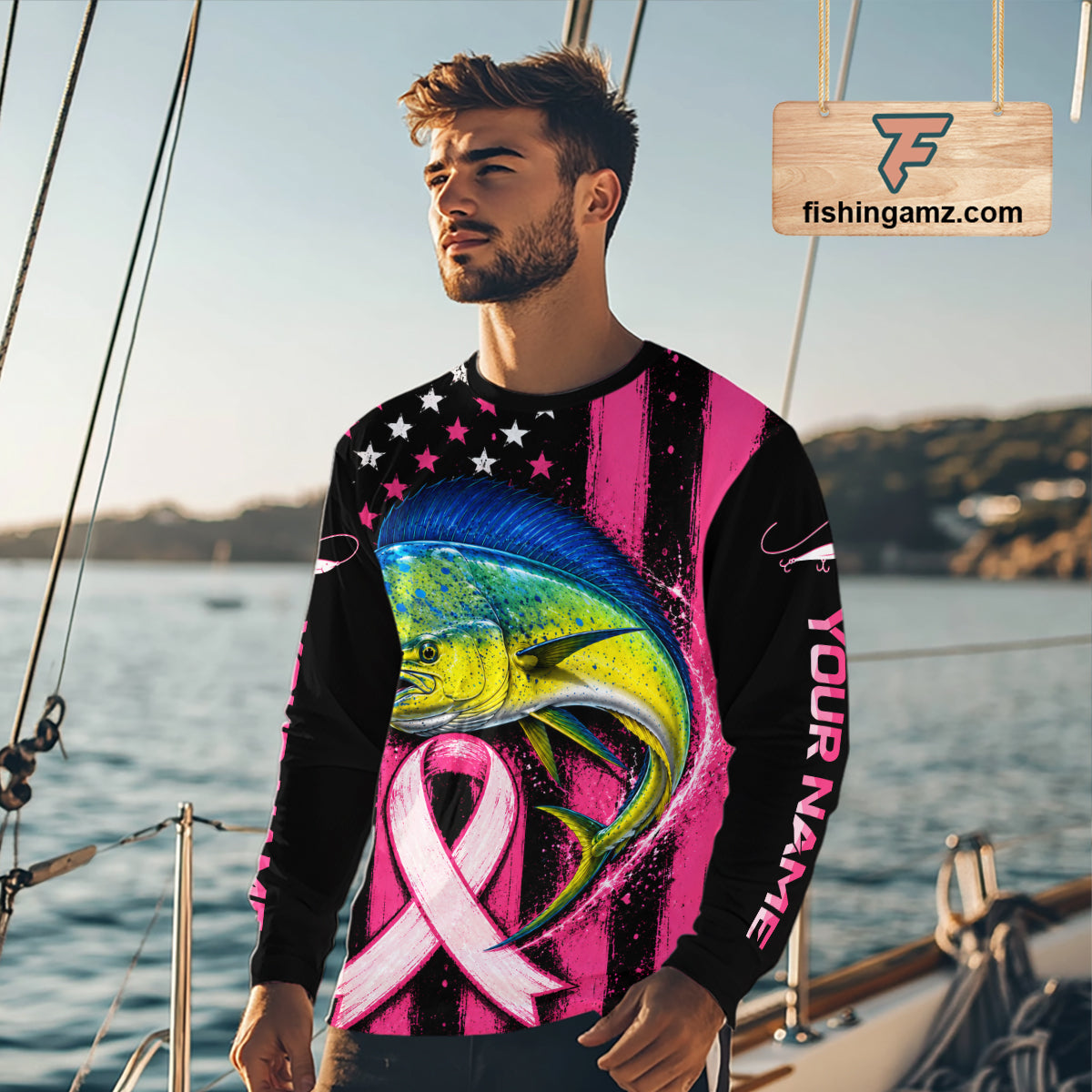 A man wearing a long-sleeve custom graphic shirt with a colorful fish design, pink and black stripes, and a pink ribbon