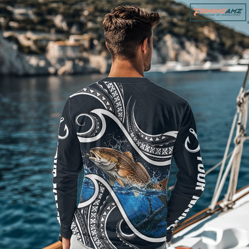 Angler wearing blue tribal pattern custom redfish long sleeve fishing shirt on the water