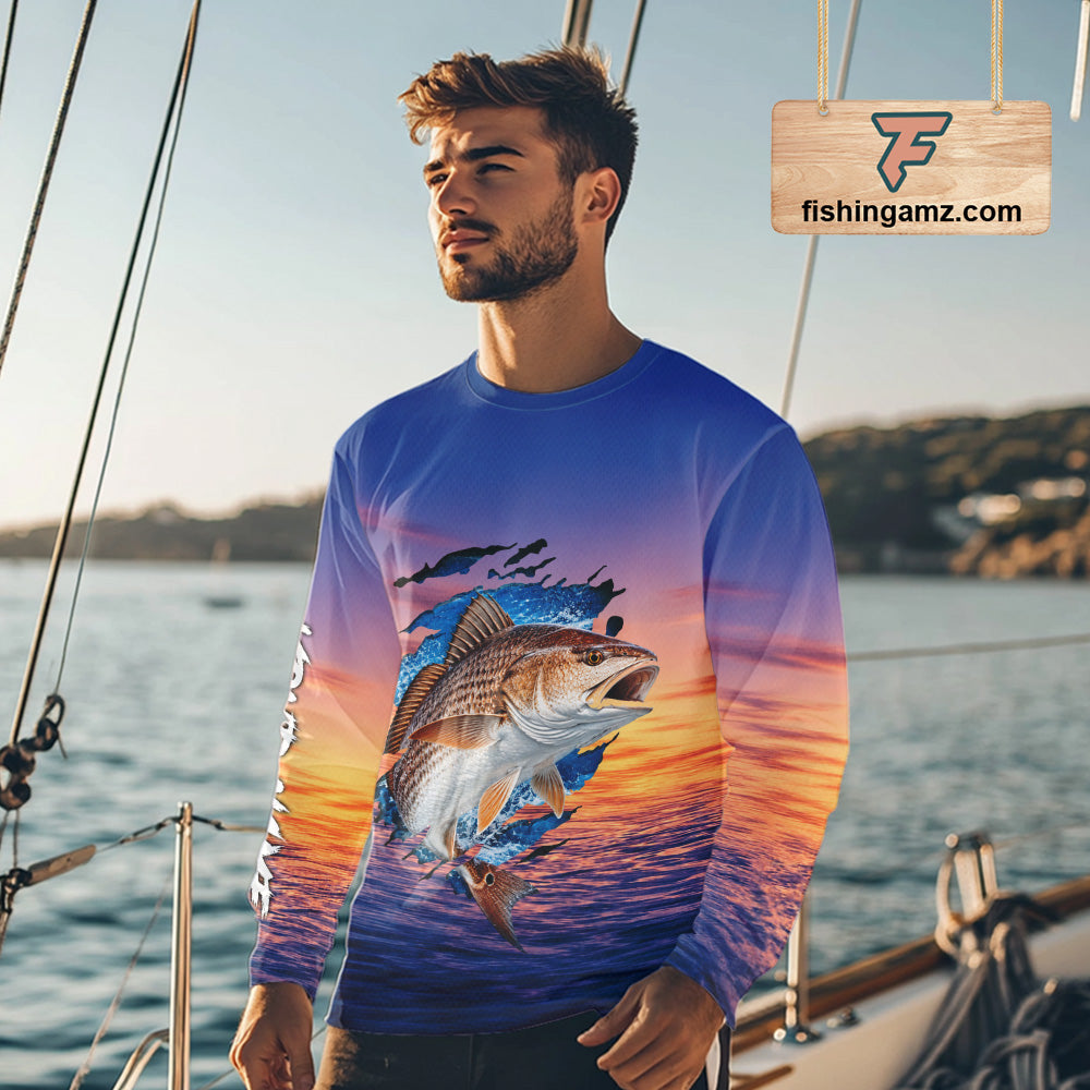Angler wearing Redfish Fishing Sunset custom long sleeve redfish offshore fishing shirt on the boat at sunset