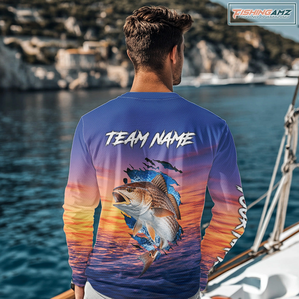 Angler wearing Redfish Fishing Sunset custom long sleeve redfish offshore fishing shirt on the boat at sunset