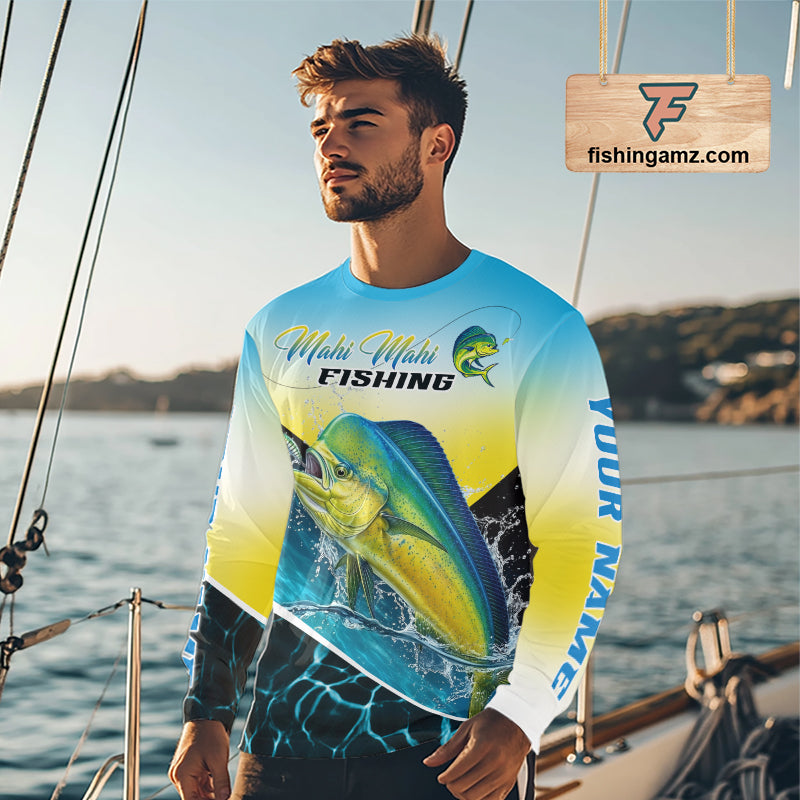 A man wearing a long-sleeve Mahi-Mahi Fishing graphic shirt on a boat deck