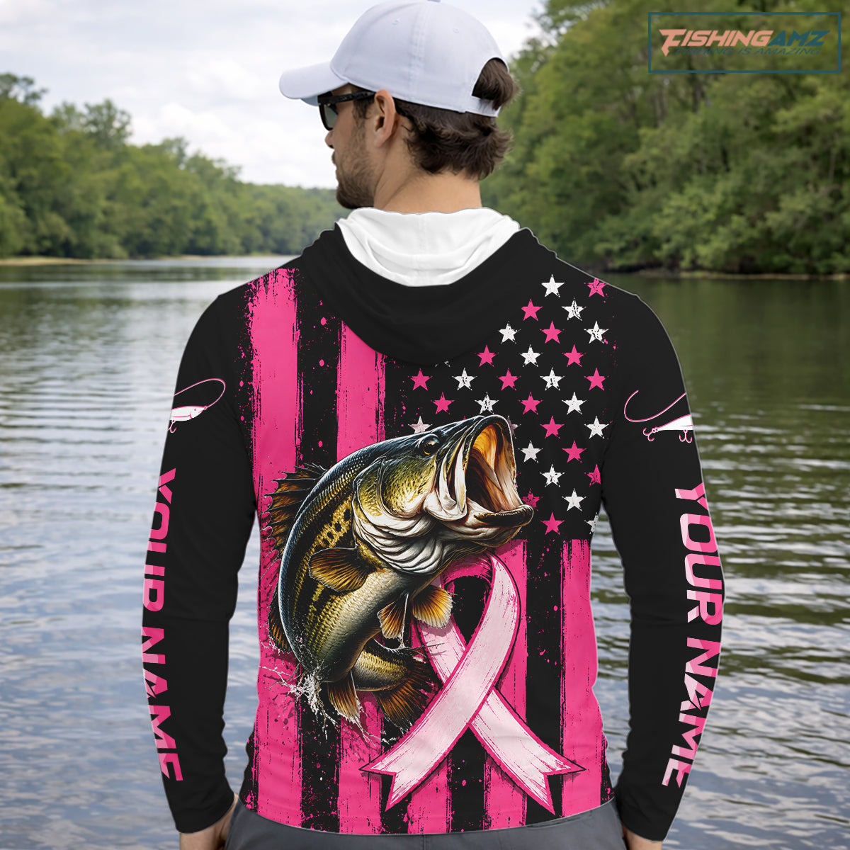 A man on a boat wearing a black and pink long-sleeve hoodie with a large graphic of a bass fish over a pink ribbon and stars-and-stripes design. The photo is taken from behind, showing the back of the hoodie in a real outdoor ocean setting.