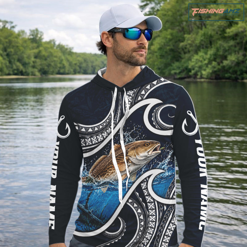 Angler wearing blue tribal pattern custom redfish long sleeve hooded fishing shirt on the water