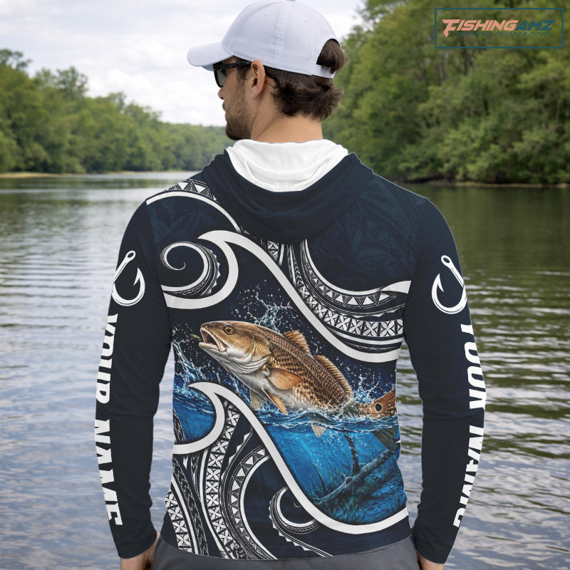 Angler wearing blue tribal pattern custom redfish long sleeve hooded fishing shirt on the water