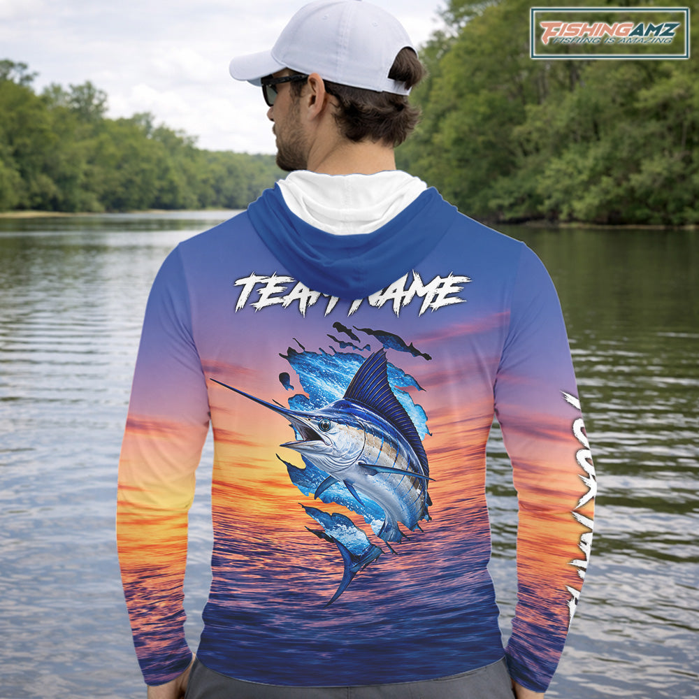 Angler wearing Marlin Fishing Sunset custom long sleeve hooded marlin offshore fishing shirt at sunset with team name on the back 