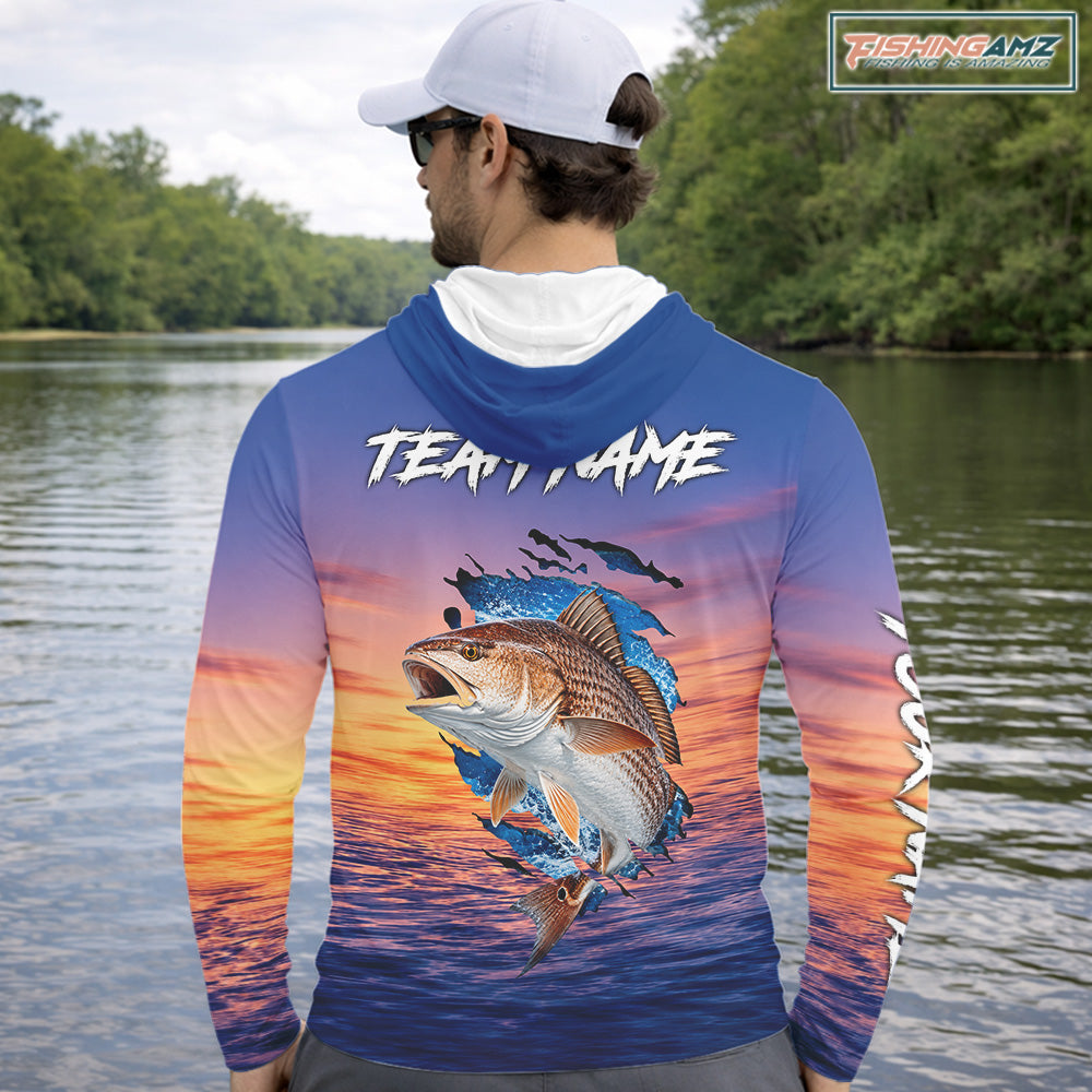 Angler wearing Redfish Fishing Sunset custom long sleeve hooded redfish offshore fishing shirt with custom team name on the back